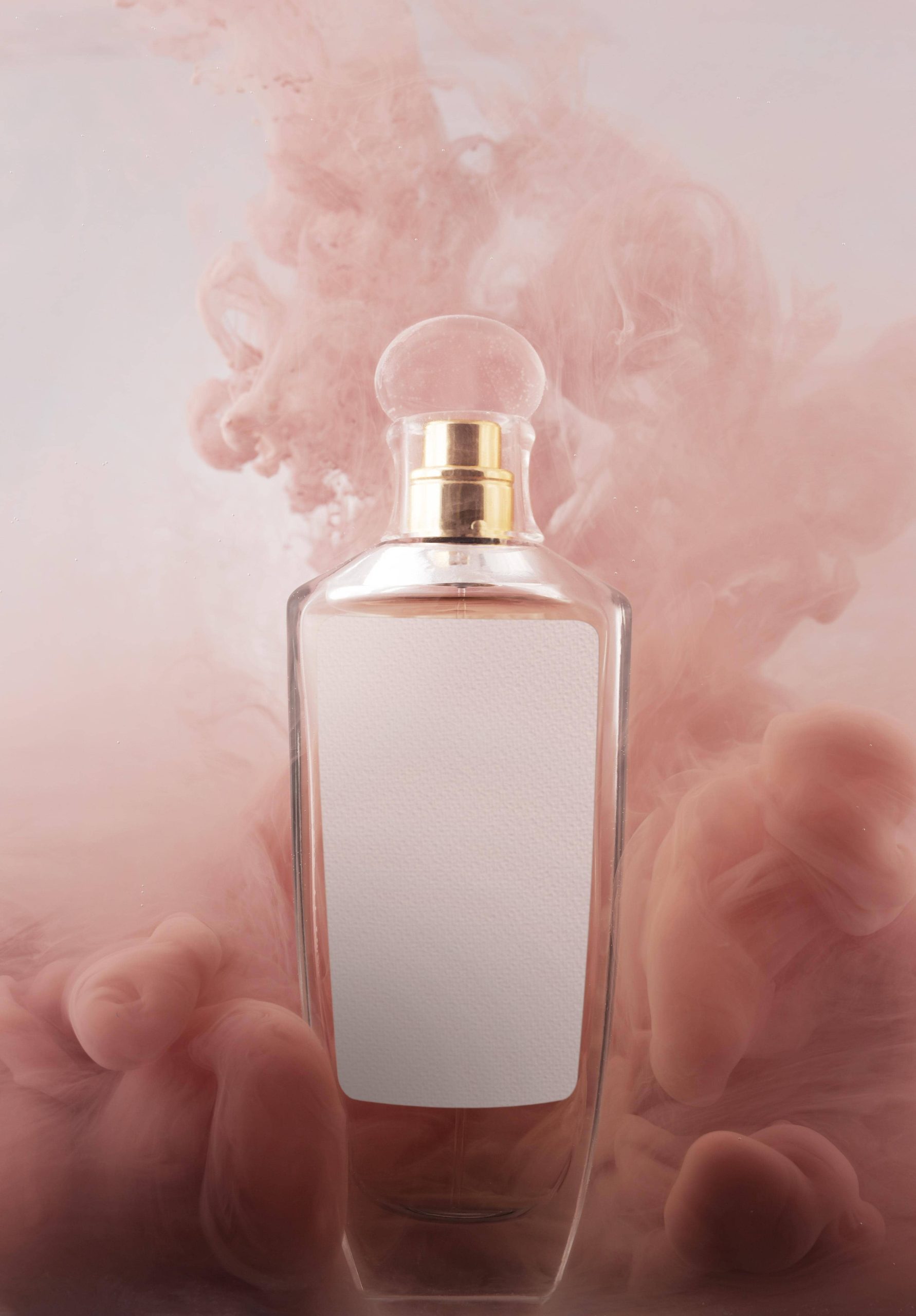 Frasco de perfume con humo rosa de fondo